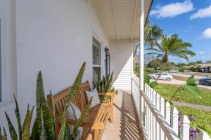 a porch with a wooden bench on a house at Beach House/KING BD/Hot Tub/Pool/Fire Pit/Gym/Golf in Lantana