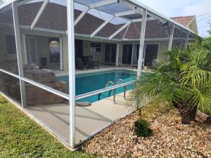 une extension en verre d'une maison avec une piscine dans l'établissement Casa in The Cove, à Cape Coral
