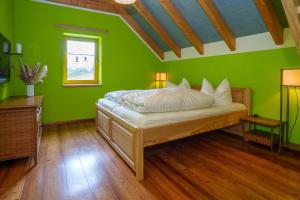 a green bedroom with a bed and a window at Landhaus Seiffen in Seiffen