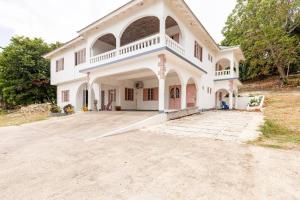 a large white house with a large driveway at Shaw Park Gem Apt 12A in Ocho Rios