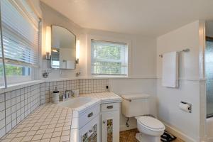 a white bathroom with a toilet and a sink at Cozy Grants Pass Home about 9 Mi to Rogue River Access in Grants Pass