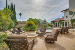 a patio with chairs and a table and a pool at Stunning Home on Golf Course about 8 Mi to Disneyland! in Buena Park