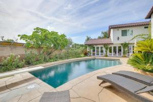 a swimming pool with two chairs and a house at Stunning Home on Golf Course about 8 Mi to Disneyland! in Buena Park