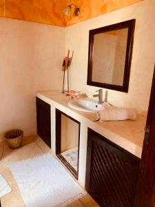 ein Bad mit einem Waschbecken und einem Spiegel in der Unterkunft Nyumba Malkia at Tembo Village in Watamu