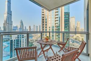 a balcony with a table and chairs and a view of the city at Burj Khalifa Front view & Fountain view Island Paradise 2BR Luxury Apartment Burj residences Golden Homes in Dubai