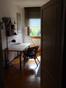 uma sala de jantar com uma mesa e cadeiras e uma janela em Casa Fantuzzi em Belluno