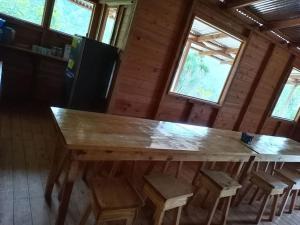 una gran mesa de madera en una habitación con taburetes en Cabaña Paraíso Verde, en Providencia