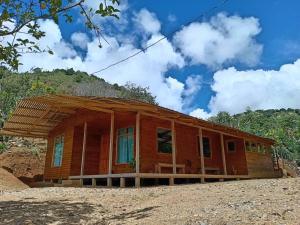 a wooden house with a roof on a field at Cabaña Paraíso Verde in Providencia