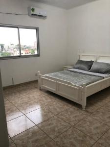 - une chambre avec un lit dans une pièce dotée d'une fenêtre dans l'établissement Appartements Haut de Guégué, à Libreville