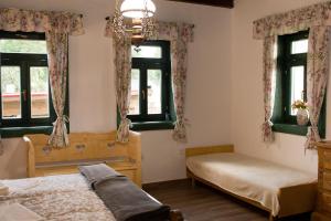a bedroom with two beds and two windows at Pinkó Vendégház in Noszvaj
