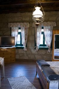 a bedroom with a bed and a tv and windows at Pinkó Vendégház in Noszvaj