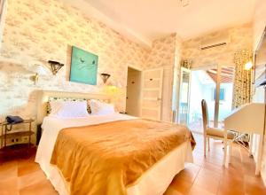 a bedroom with a bed and a table and a desk at Plaza Corniche in La Marsa