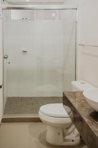 a bathroom with a toilet and a glass shower at a 5 min de la playa alberca privada by G P S rentas in Mazatlán +13 photos