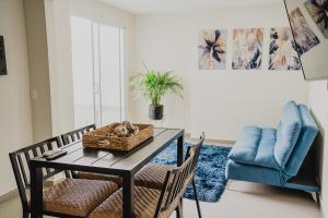 a dining room with a table and a blue chair at a 5 min de la playa alberca privada by G P S rentas in Mazatlán