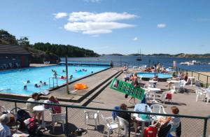 a group of people sitting around a swimming pool at Hytte på sørlandet in Kristiansand