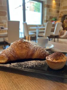 ein Laib Brot und ein Gebäck auf einer Platte in der Unterkunft Standard Room in Pulsano