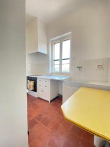 une cuisine avec un comptoir jaune et une table jaune dans l'établissement Charmant haut de villa T3, à Saint-Cyr-sur-Mer