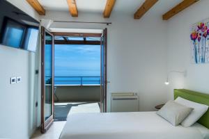 een slaapkamer met een bed en uitzicht op de oceaan bij Villa Marone in Opatija