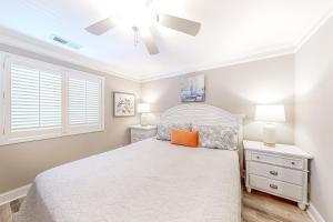 a bedroom with a white bed and a ceiling fan at Hook Wine and Sinker in Myrtle Beach