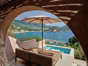 a patio with an umbrella and a swimming pool at ISAVORIA ECO CHIC RESORT in Parga