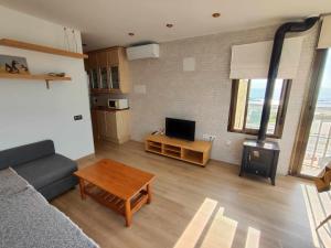 sala de estar con sofá, TV y mesa en Ático Las Minvas 1ª linea de playa, en Grao de Castellón