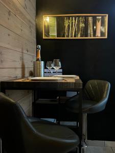 stolik z dwoma kieliszkami wina i butelką szampana w obiekcie Loft Zen Essentiel w mieście Bonsin