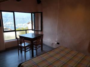 a room with a table and two chairs and a window at casa tarcisio in Faggeto Lario 