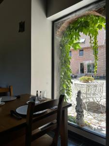a dining room with a table and a large window at De Verborgen Parel B&B in Borgloon