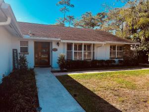 a white house with a brown door and a sidewalk at Sweet Home/WEF/LionCountrysafary in Wellington