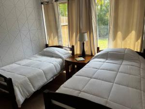two beds sitting in a room with a window at Sweet Home/WEF/LionCountrysafary in Wellington