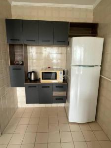 a kitchen with a white refrigerator and a microwave at Apartamento próximo ao metro Jabaquara, apto 47 in São Paulo