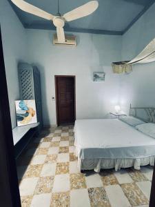 - une chambre avec un lit et un ventilateur de plafond dans l'établissement Bless, à Tela