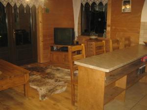 uma sala de estar com uma mesa e cadeiras e uma televisão em Słoneczny Apartament em Czarna Góra
