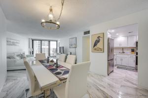 a dining room and living room with a table and chairs at Beachfront Marco Island Condo with Pool Access! in Marco Island