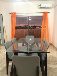 a glass dining room table with chairs and a window at Appartements Haut de Guégué in Libreville