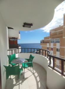 balcón con mesa, sillas y vistas al océano en Casa Yuni, en Candelaria