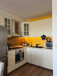 una cucina con mobili bianchi e un lavandino di Apartment Stella a Varna