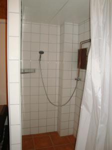 een douche met een slang in een wit betegelde badkamer bij Maison de vacances Alsace - Ferienhaus Elsaß - Holiday house Alsace in Bischwiller
