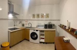 a kitchen with a sink and a washing machine at Miniloft en la playa in Alicante