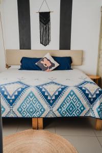 ein Bett mit einer blau-weißen Decke drauf in der Unterkunft Mareta 201 Hermoso cerca de la playa in Mazatlán