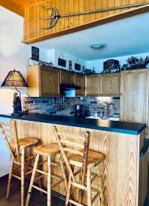 a kitchen with a counter with two chairs and a counter top at Panorama Hak - CharmingStay in Flumserberg