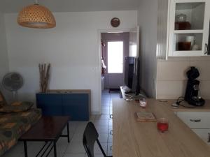eine Küche und ein Wohnzimmer mit einem Tisch und einem TV in der Unterkunft FACE à LA PLAGE CENTRALE POUR CET AGRÉABLE T2 in Capbreton