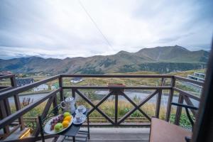 a bowl of fruit on a table on a balcony with mountains at Chalet Papa Basili in Gudauri