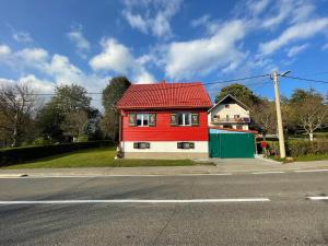 a red house on the side of a street at Kuća za odmor Elf in Kupjak