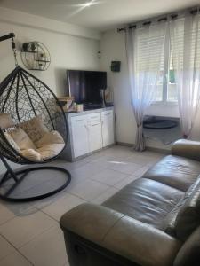 ein Wohnzimmer mit Sofa und Schaukel in der Unterkunft chambre chez hôte in Sainte-Eulalie