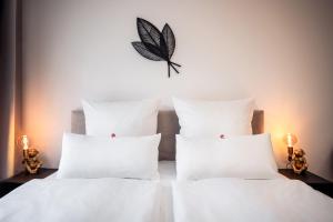 德勒斯登的住宿－NK Apartments - Hafencity Dresden mit Elbblick - Modern & Zentral，一张带白色枕头的床和墙上的蝴蝶