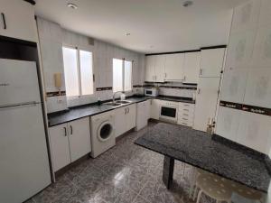 eine Küche mit weißen Schränken und einer Waschmaschine und einem Trockner in der Unterkunft Las Minvas Teatro in Castellón de la Plana
