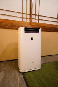 a small white refrigerator sitting on a floor at HOTEL Lee in Tokyo