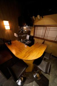 a wooden table in a kitchen with black chairs at HOTEL Lee in Tokyo