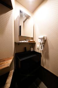 baño con lavabo negro y espejo en HOTEL Lee, en Tokio